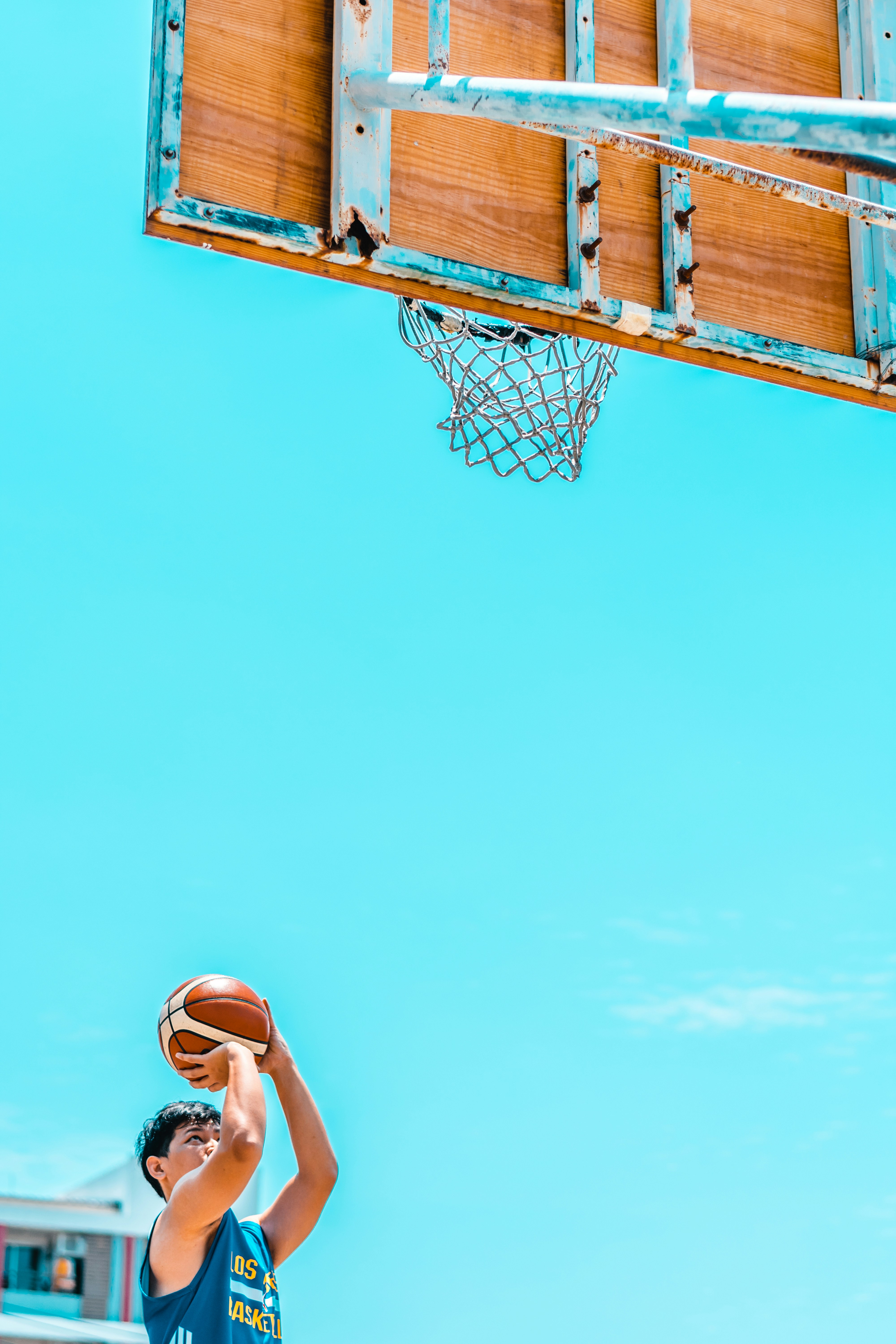 Young athlete shooting basketball at outdoor hoop